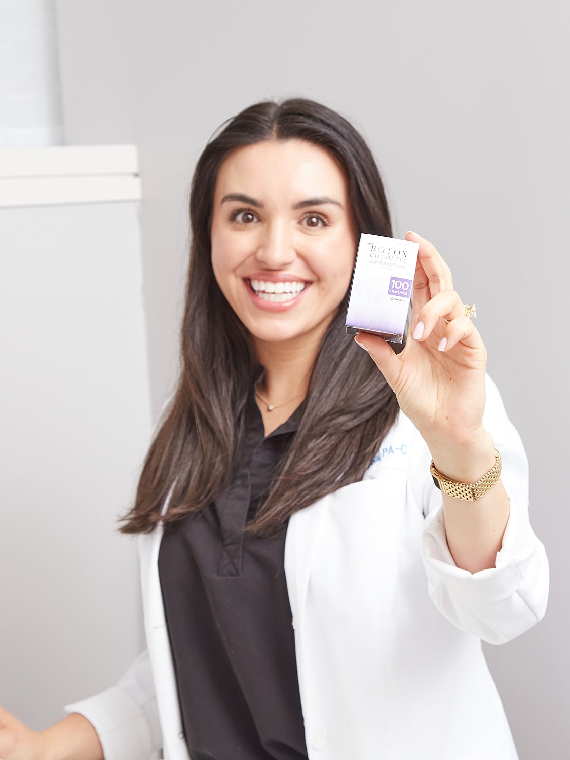 Smiling healthcare professional holding Botox product.
