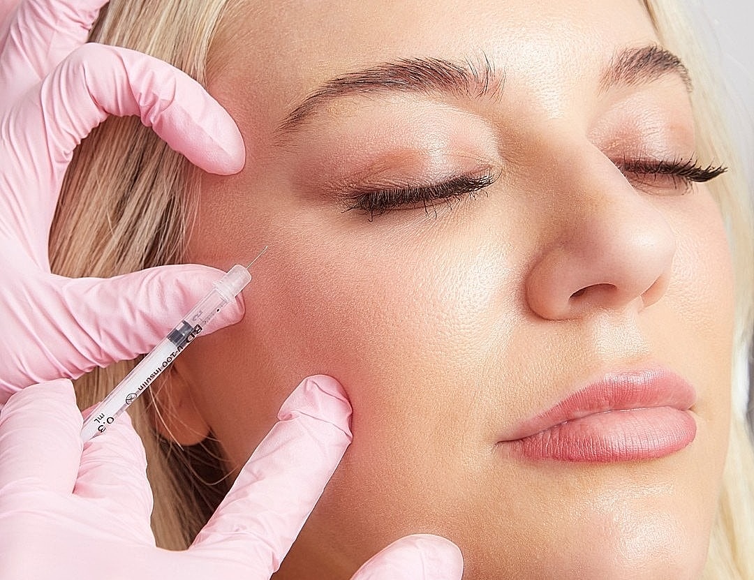 Woman receiving cosmetic injection treatment.