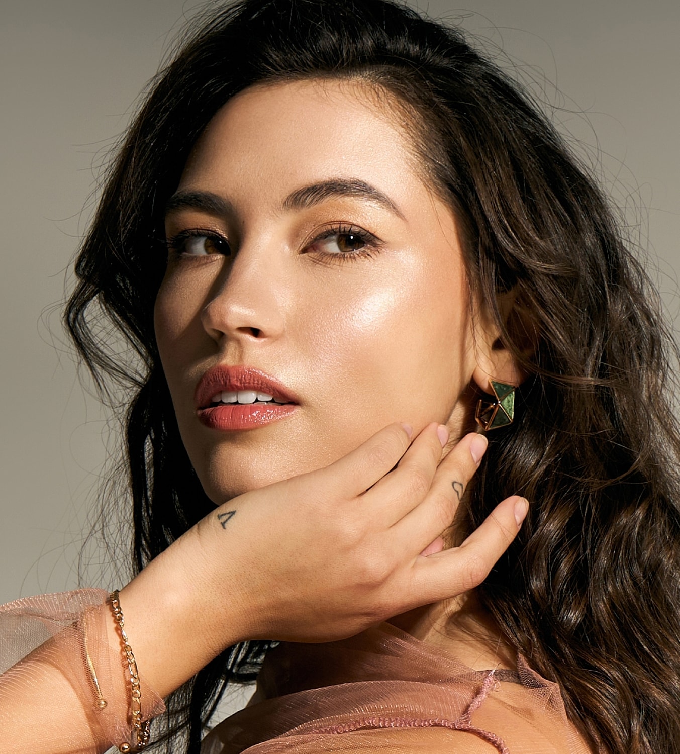 Woman with earrings and elegant makeup pose.