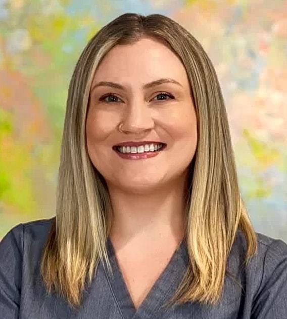 Smiling woman in professional attire against colorful background.