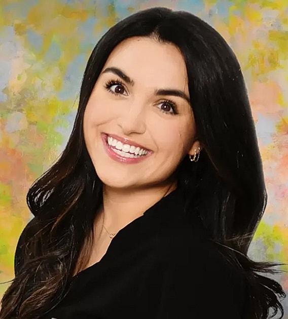 Smiling woman with long dark hair, colorful background.