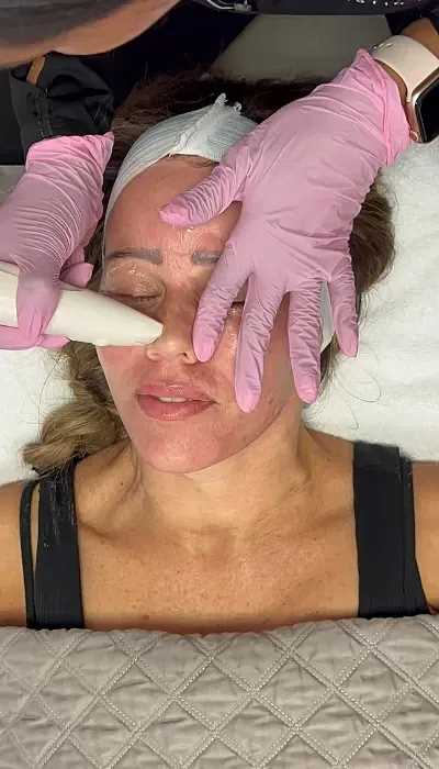 Skincare treatment with tools and gloved hands.