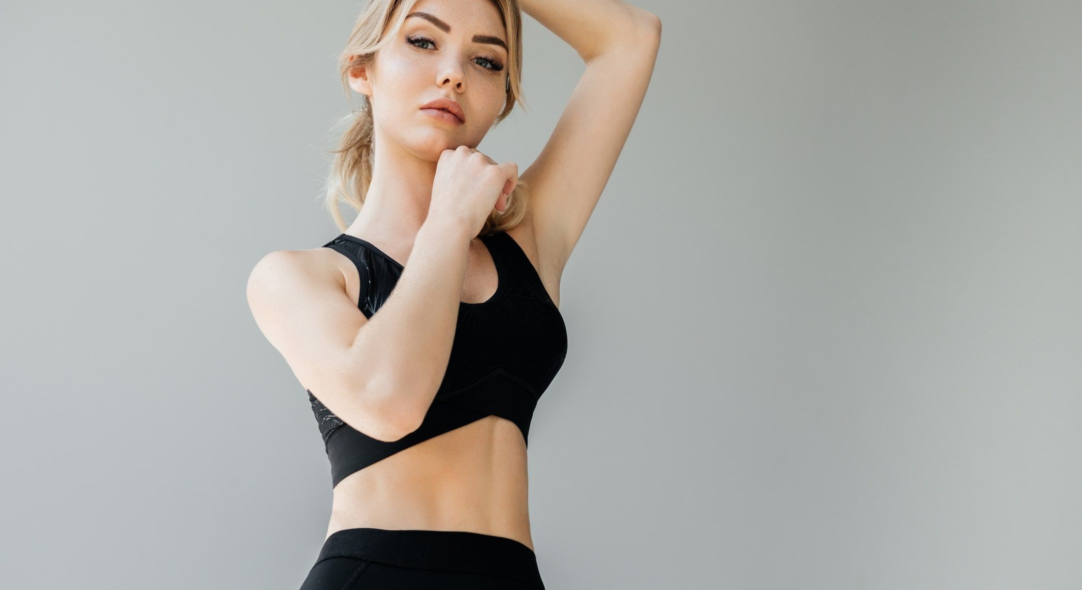 Model posing in activewear against a neutral background.