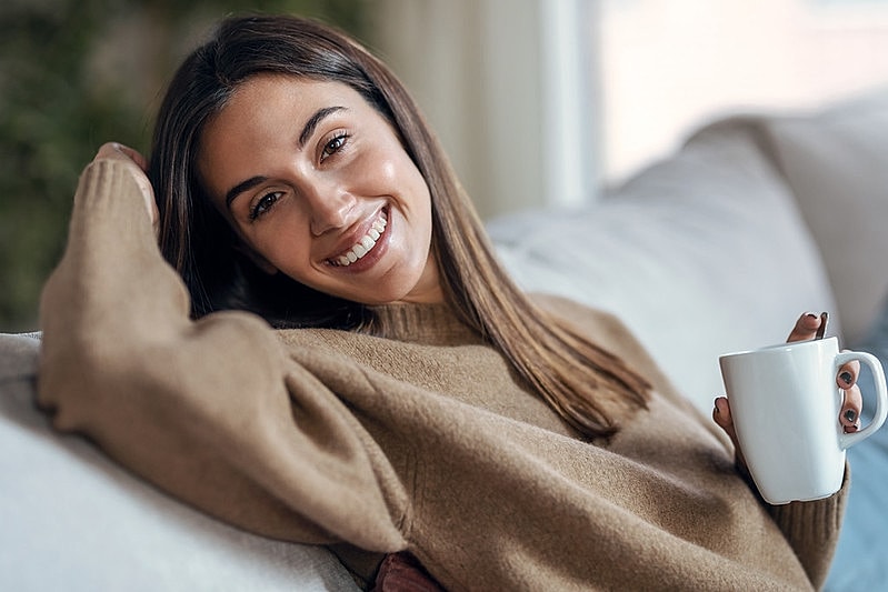 Smiling woman relaxing with a coffee cup.